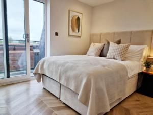a bedroom with a large bed with a large window at Dorchester Centre Apartment - Free Parking & Views in Dorchester