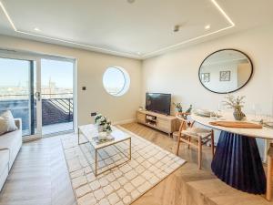 a living room with a table and a tv at Dorchester Centre Apartment - Free Parking & Views in Dorchester