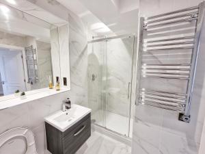 a white bathroom with a sink and a shower at Dorchester Centre Apartment - Free Parking & Views in Dorchester +22 photos