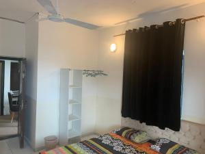 1 dormitorio con cama y cortina negra en Brise de Mer Apartment Three Bedrooms, en Yibuti