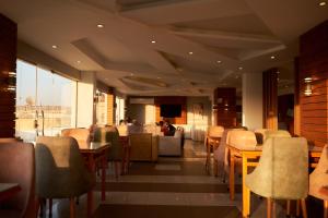 a restaurant with tables and chairs and a couch at Royal Nine Pyramids View Hotel in Cairo