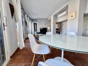 マッゼオにあるVilla Incanto di Mareのガラスのテーブルと白い椅子のあるダイニングルーム