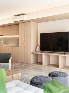 a living room with a large television and chairs at Leu boutique condos in Cancún