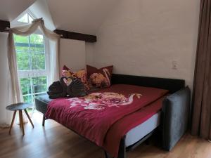 a bedroom with a bed with a purple blanket at Ferienhaus Heidefee in Wietzendorf