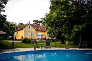 a house with a swimming pool in front of a house at Tusculanum Udvarház in Mindszentkálla