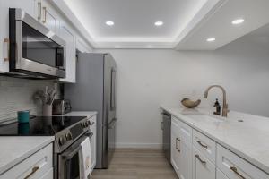 a kitchen with white counters and a stainless steel refrigerator at Sundial F403 - Beach Bliss in Sanibel