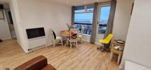 a living room with a table and a large window at Central Worthing, seafront ,balcony flat in Worthing