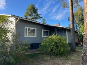 a gray house with trees in front of it at Lemminkäinen in Kokkola