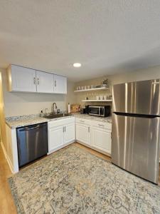 a kitchen with a stainless steel refrigerator and white cabinets at Hillside Retreat in Knoxville