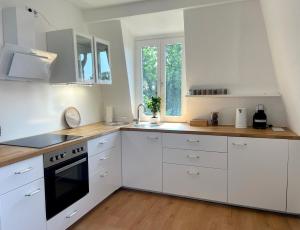 a kitchen with white cabinets and a stove top oven at blue rooms in Schweinfurt