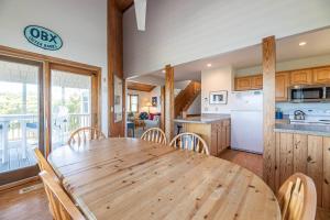 a kitchen and dining room with a wooden table and chairs at Serenity in Duck D4118 - 3 Min Walk to the Beach, Community Pool! in Duck