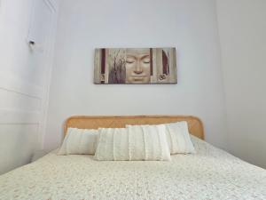 una camera da letto con un letto e un quadro sul muro di La petite maison au bord du Loir a Brévainville