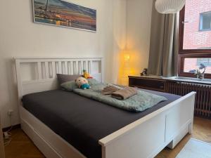 una cama con un osito de peluche sentado encima en Stylish Apartment in the Heart of Hamburg, en Hamburgo
