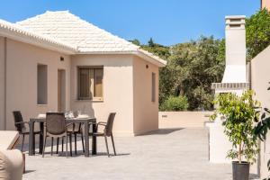 a patio with a table and chairs on a house at OliveΒayVilla in Tragaki +34 photos
