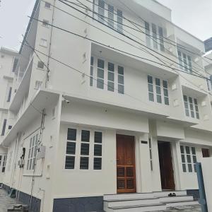 a white building with two doors on it at Sivasarass rooms in Trivandrum