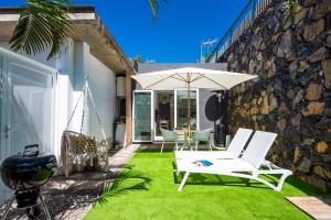 eine Terrasse mit einer Hängematte und einem Sonnenschirm in der Unterkunft Little LuxuryHouse Puerto de la Cruz in Puerto de la Cruz