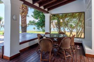 a patio with a glass table and chairs on a deck at Villa Mar de Luz - Seafront Residence in Santa Eularia des Riu