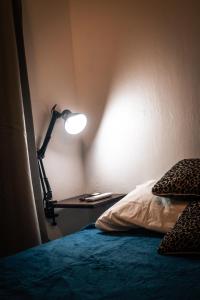 eine Lampe auf einem Tisch neben einem Bett in der Unterkunft Numá Lior Departamentos - Casco Histórico in San Miguel de Tucumán + 25 Fotos