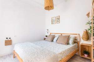ein weißes Schlafzimmer mit einem Bett mit Kissen in der Unterkunft Little LuxuryHouse Puerto de la Cruz in Puerto de la Cruz