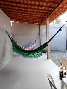eine Hängematte auf einer Terrasse mit einem Tisch und Stühlen in der Unterkunft Casa Morada Nobre2 in Barreirinhas