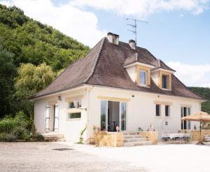 a small white house with a roof at Riverside Retreat in Badefols-sur-Dordogne