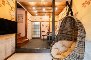 a hanging chair in a living room with a television at EDO GATEI Sakura Biyori Stay in Tokyo