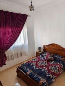 a bedroom with a bed with a purple curtain at Apartment in Villa - Tangier in Tangier
