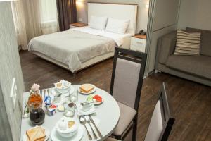 Apart Hotel Kvartira 1 في أوديسا: غرفة بها سرير وطاولة عليها طعام
