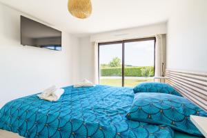 a bedroom with a blue bed and a window at Borda in Mouguerre