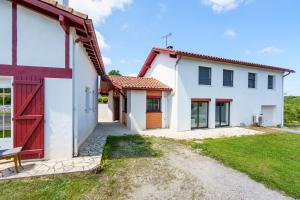 a large white house with a red door at Borda in Mouguerre