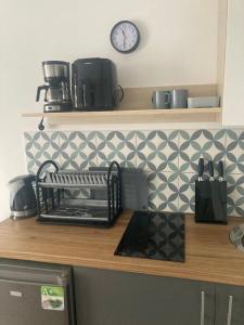 a kitchen counter with a clock on the wall at Apartament 44A, Dębina in Debina