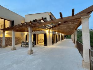 un patio al aire libre con pérgola de madera en Villa Horizonte - Luxury Above Puerto de Andratx, en Andratx