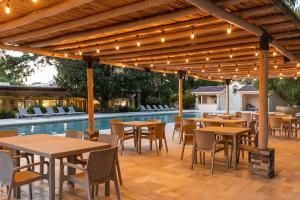 a patio with tables and chairs next to a pool at Rincón Del Montero in Parras de la Fuente