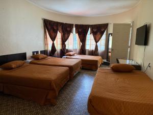 a hotel room with three beds and a television at Hotel Mayesstic in Guatemala