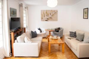 a living room with two white couches and a table at Riverside Retreat in Badefols-sur-Dordogne
