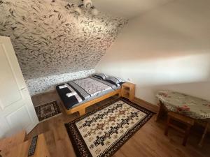 a small room with a bed and a rug at Korond Mako panzio in Corund