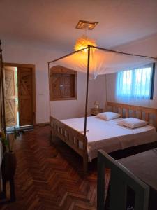 une chambre avec un grand lit à baldaquin dans l'établissement Oasis Kemba Hôtel-Restaurant-Bar, à Toliara 28 autres photos