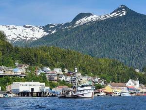 a boat in a body of water with a mountain at Coho Bungalow - Ketchikan Alaska in Ketchikan