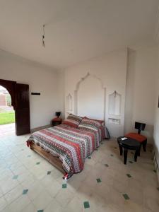 ein Schlafzimmer mit einem Bett und einem Tisch darin in der Unterkunft Dar Talat in Tahannaout + 13 Fotos