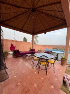 eine Terrasse mit einem Tisch, Stühlen und einem Sofa in der Unterkunft Dar Talat in Tahannaout