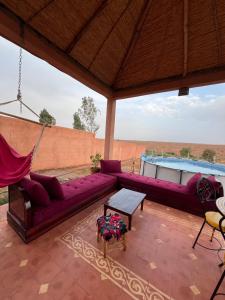 ein Wohnzimmer mit einem lila Sofa und einer Hängematte in der Unterkunft Dar Talat in Tahannaout