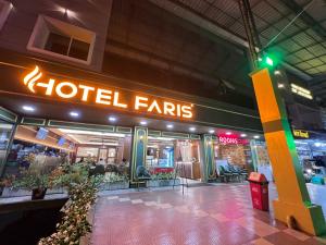 a store front of a hotel with a neon sign at Near Calicut International Airport - HOTEL FARIS in Malappuram