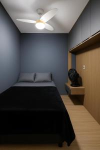 une chambre avec un lit et un ventilateur de plafond dans l'établissement HighView Urban - Modern Rooms, à Rio de Janeiro