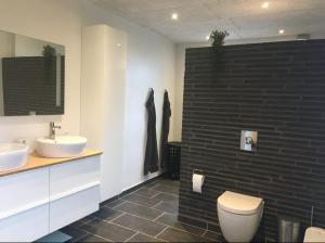 ein Badezimmer mit einer weißen Toilette und einem Waschbecken in der Unterkunft House Sea Beach Vacation Denmark Ferienhaus Dänemark Urlaub Privatunterkunft in Sarup + 26 Fotos