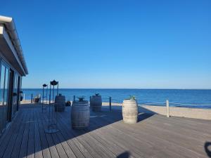 eine Promenade mit Fässern an einem Strand mit Blick auf das Meer in der Unterkunft House Sea Beach Vacation Denmark Ferienhaus Dänemark Urlaub Privatunterkunft in Sarup