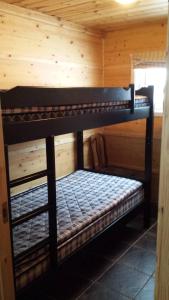 2 Etagenbetten in einer Hütte mit Holzwänden in der Unterkunft Breifossen hytteutleie in Namsskogan