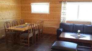 ein Esszimmer mit Tisch und Stühlen und einer Couch in der Unterkunft Breifossen hytteutleie in Namsskogan + 4 Fotos