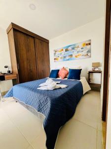 a bedroom with a blue bed with a towel on it at Villas del mar in Cartagena de Indias +15 photos