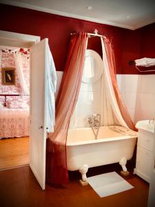 a bathroom with a tub with a window and a bed at VILLA la GLORIETTE in Rouen