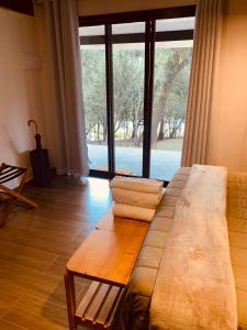 a living room with a couch and a large window at Bangalô 2 Rota do Vinho São Roque in São Roque